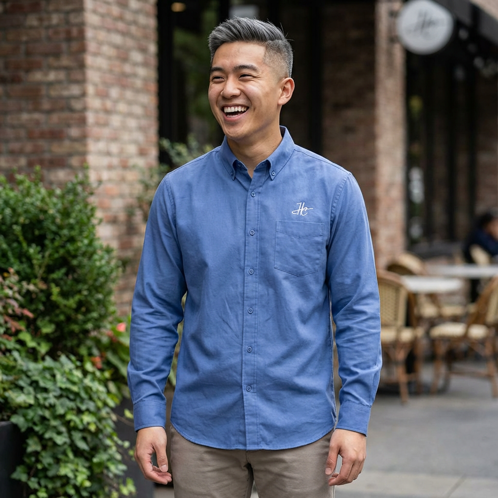 Man wearing a blue shirt with a logo, standing outdoors.